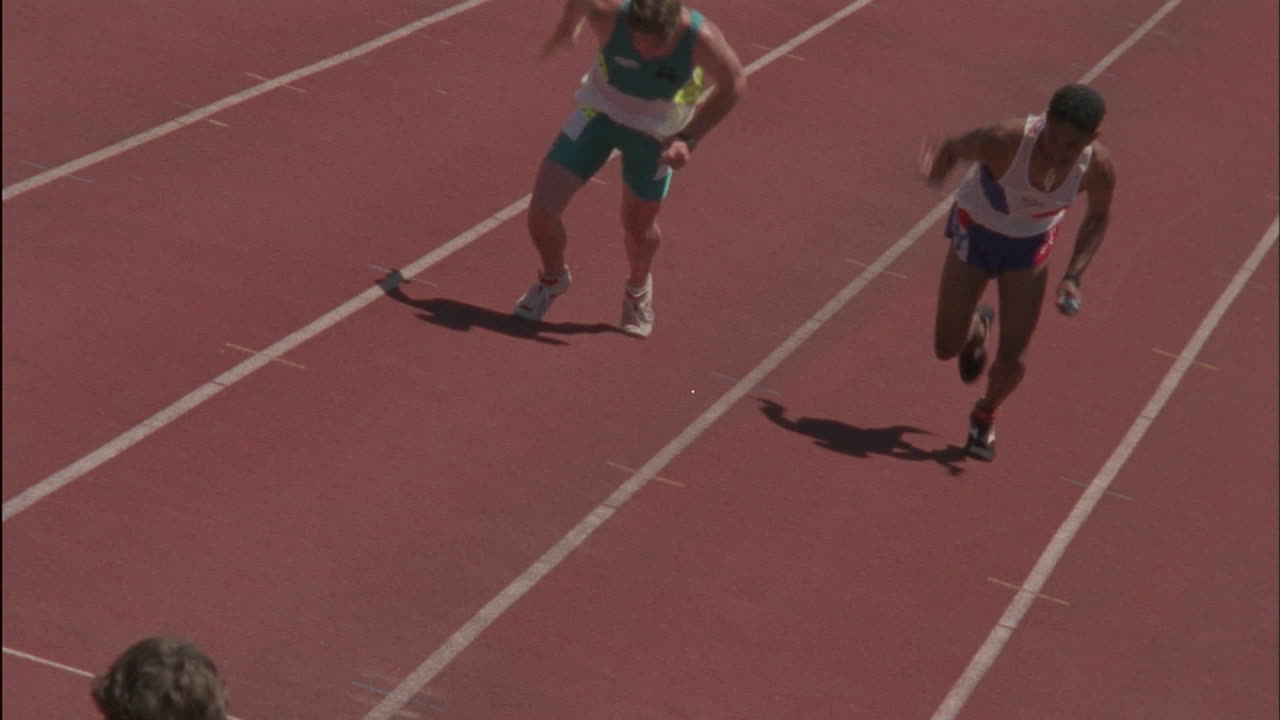 los corredores masculinos entregan el testigo en una carrera de relevos.