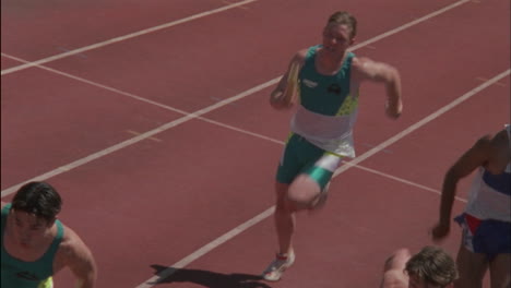 male runners hand off the baton in a relay race