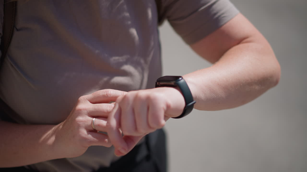 Close up of office clerk glancing at smartwatch to check time under bright daylight, subtle shadows on neutral shirt fabric, gesture reflecting punctuality, awareness, and professional focus