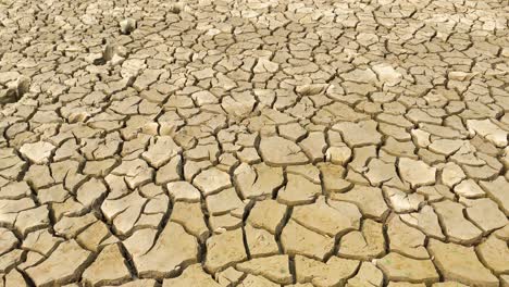 pan over bright cracked dry soil ground during drought in bangladesh