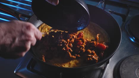 hacer quesadilla de pavo molido en sartén caliente con envoltura de tortilla y huevo revuelto