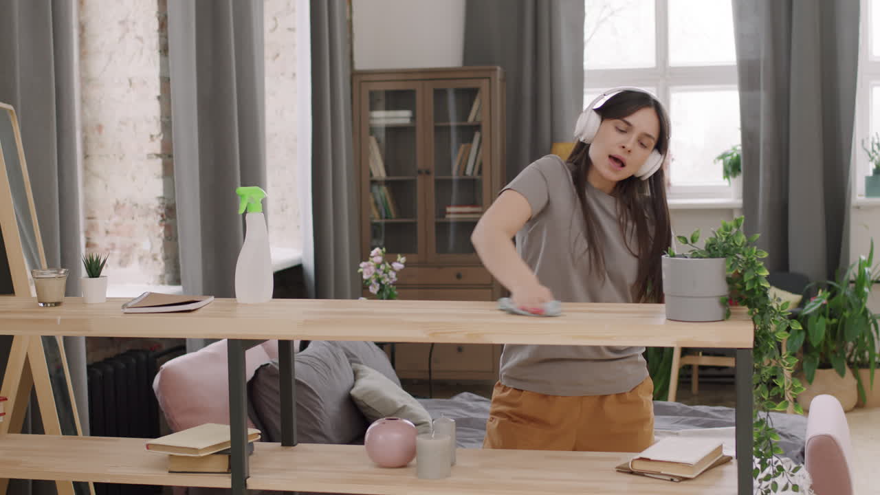 Happy Woman Enjoying Music and Cleaning Apartment