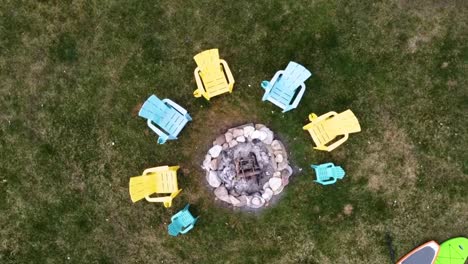 Drone-circling-over-campfire-with-Muskoka-chairs-around-it-in-Kawartha