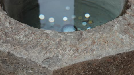 coins resting in a stone fountain