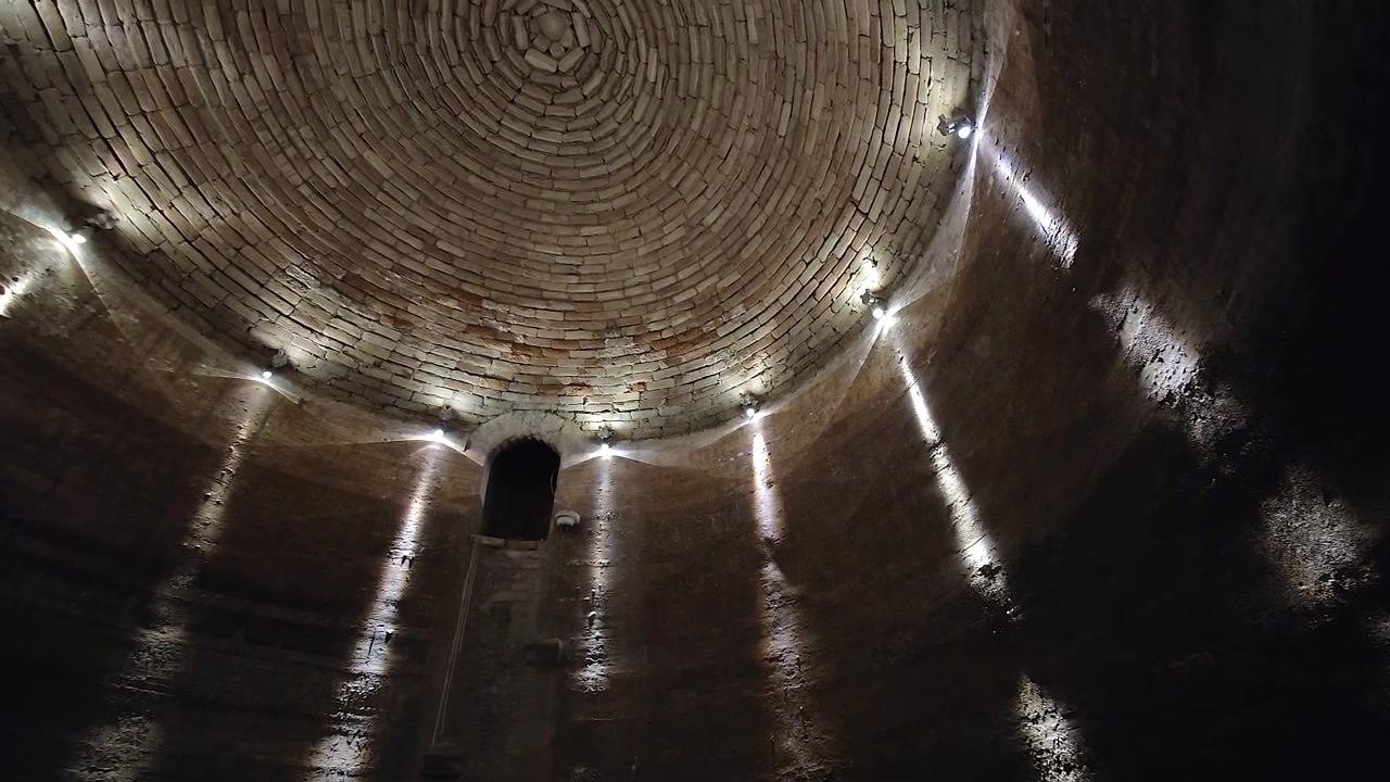 Vista interna di un'antica cisterna in pietra con soffitto a cupola circolare