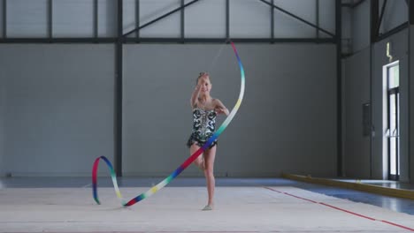 teenage female gymnast performing at sports hall