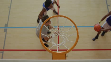 Overhead-view-of-african-american-male-basketball-player-scoring-goal-against-diverse-players