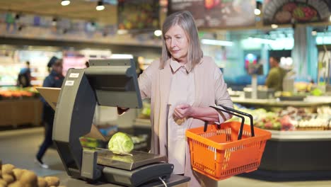 senior mature retired woman shopper weighs groceries, vegetables in supermarket, grocery store. female retiree customer makes purchases on scales on food market disappointed