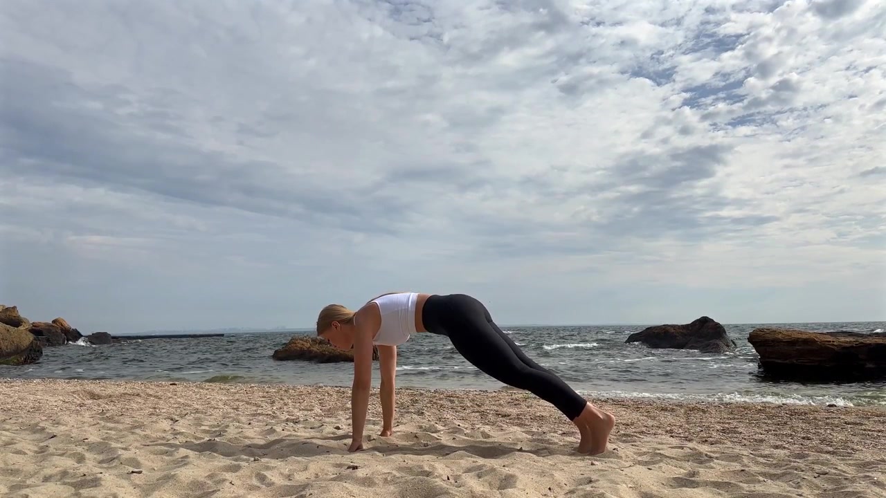 Young Woman Performing Yoga Plank Pose on Sandy Beach
