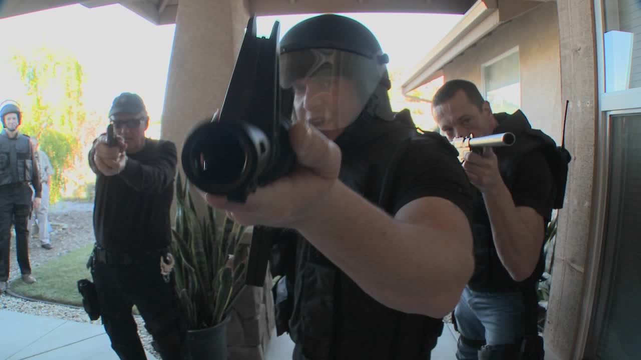 oficiales de la dea con los brazos en alto realizan un allanamiento de drogas en una casa 2