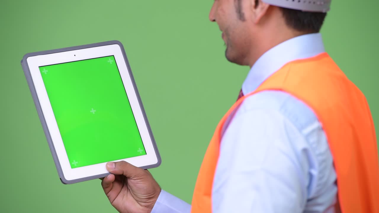Young handsome Persian man construction worker showing digital tablet