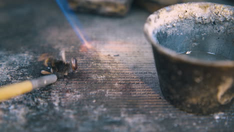 jeweler covers gold detail with material on table closeup