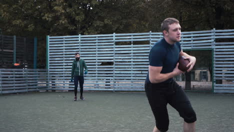 two men playing football on an outdoor field