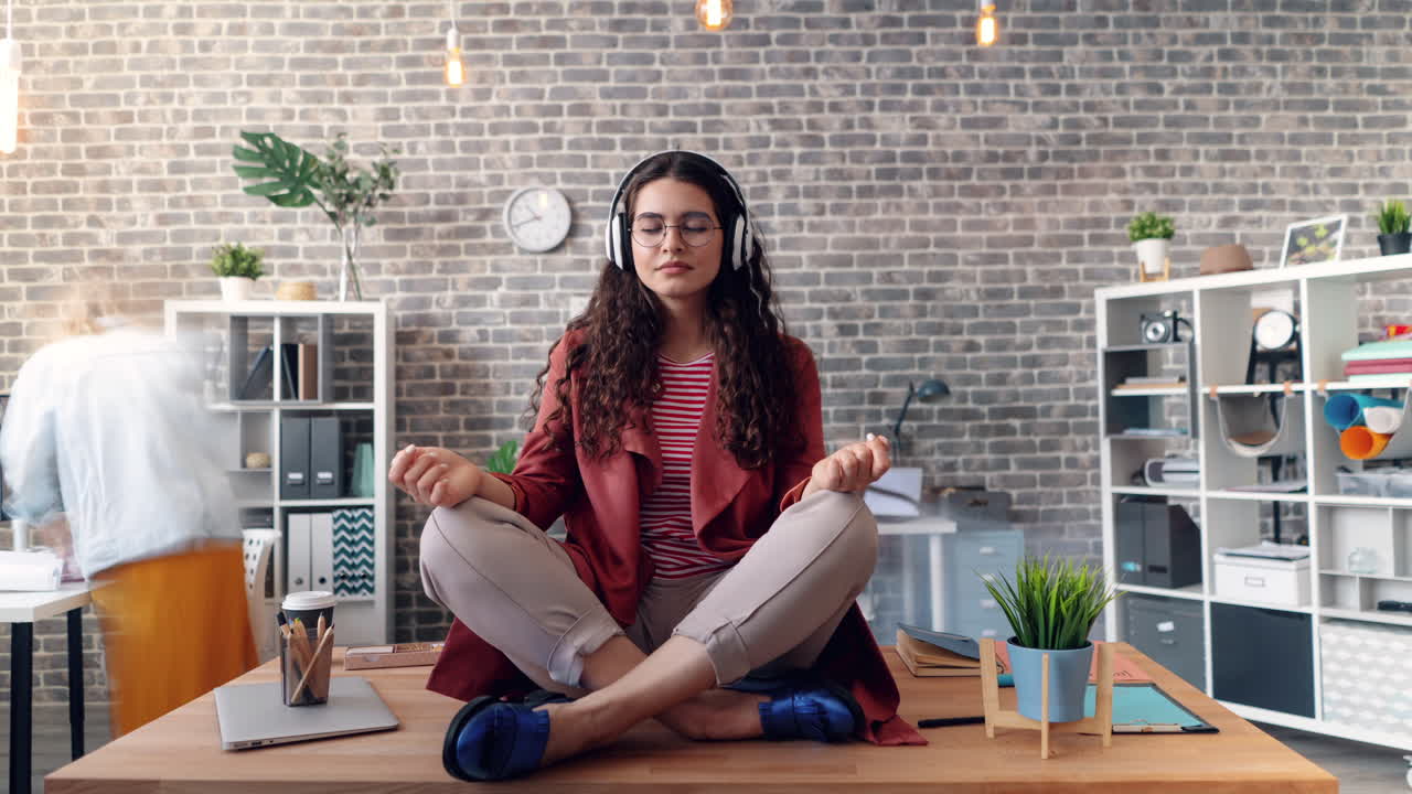 una mujer meditando en su escritorio.
