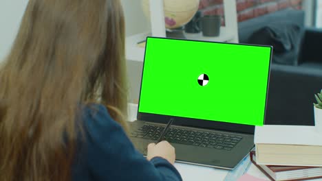 child little girl lesson homework online at home. distance education with children, online class or e-learning. laptop web camera and make video call. display with green screen.