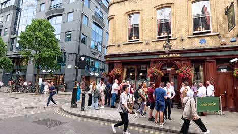 personas caminando y reuniéndose cerca de un pub