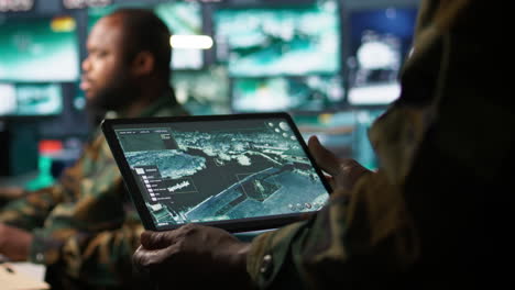 operador de sistemas de telecomunicaciones del ejército que utiliza software de satélite en tableta
