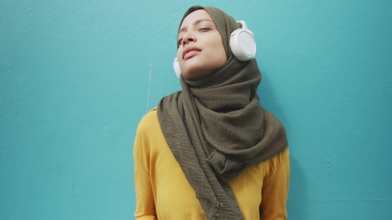 Woman wearing hijab with wireless headphone