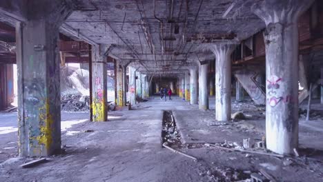 an aerial over rap artists singing and dancing inside an abandoned factory in detroit