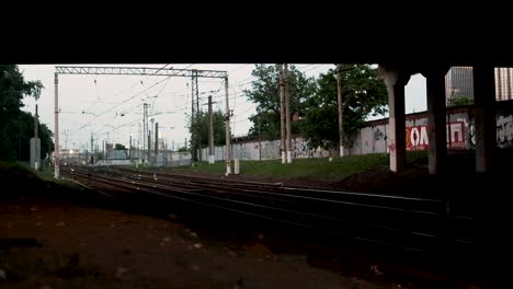 las vías del tren bajo un puente al crepúsculo