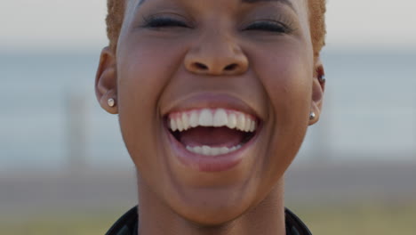 Portrait-of-happy-African-american-young-woman-smiling-outdoors-at-the-ocean-enjoying-calm-lifestyle