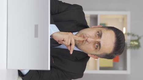 vertical video of home office worker man says shhh to camera.