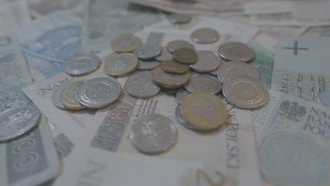 monedas polacas dispersas en billetes desplegados