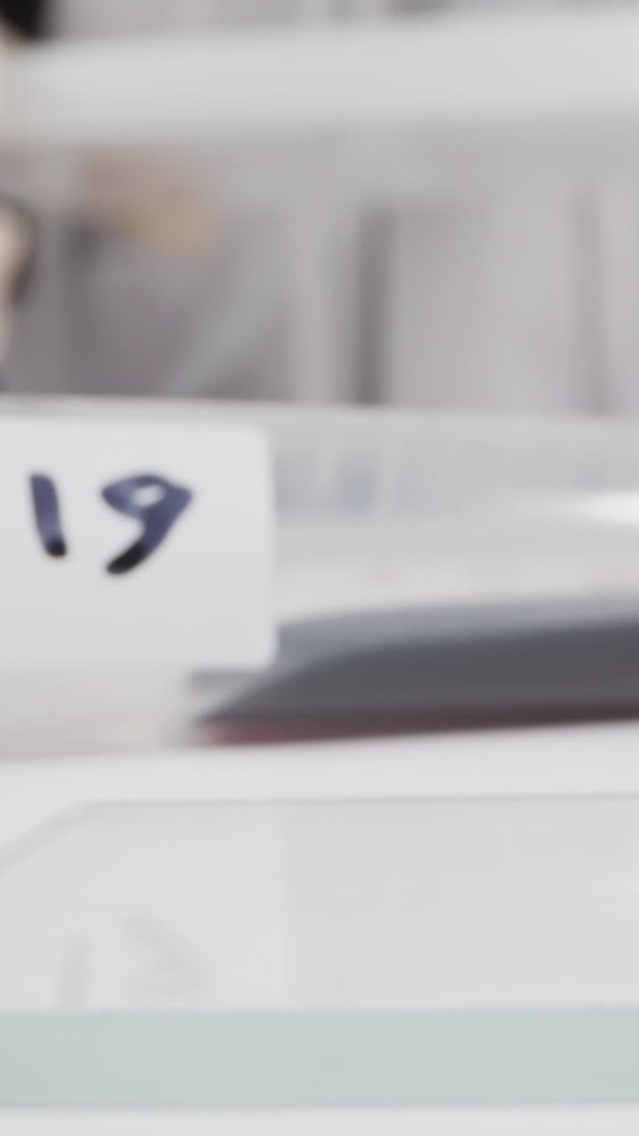 Test tube with blood sample and tag Covid on table and woman working in lab slow motion. Probe lens footage of coronavirus research macro view