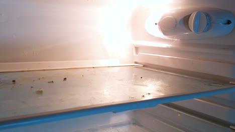 Zoom-out-hand-held,-of-an-empty-dirty-fridge