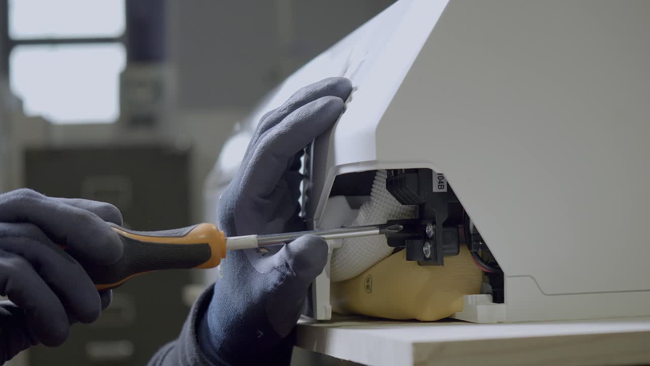 técnico eléctrico con guantes desenrosca la pieza del aire acondicionado