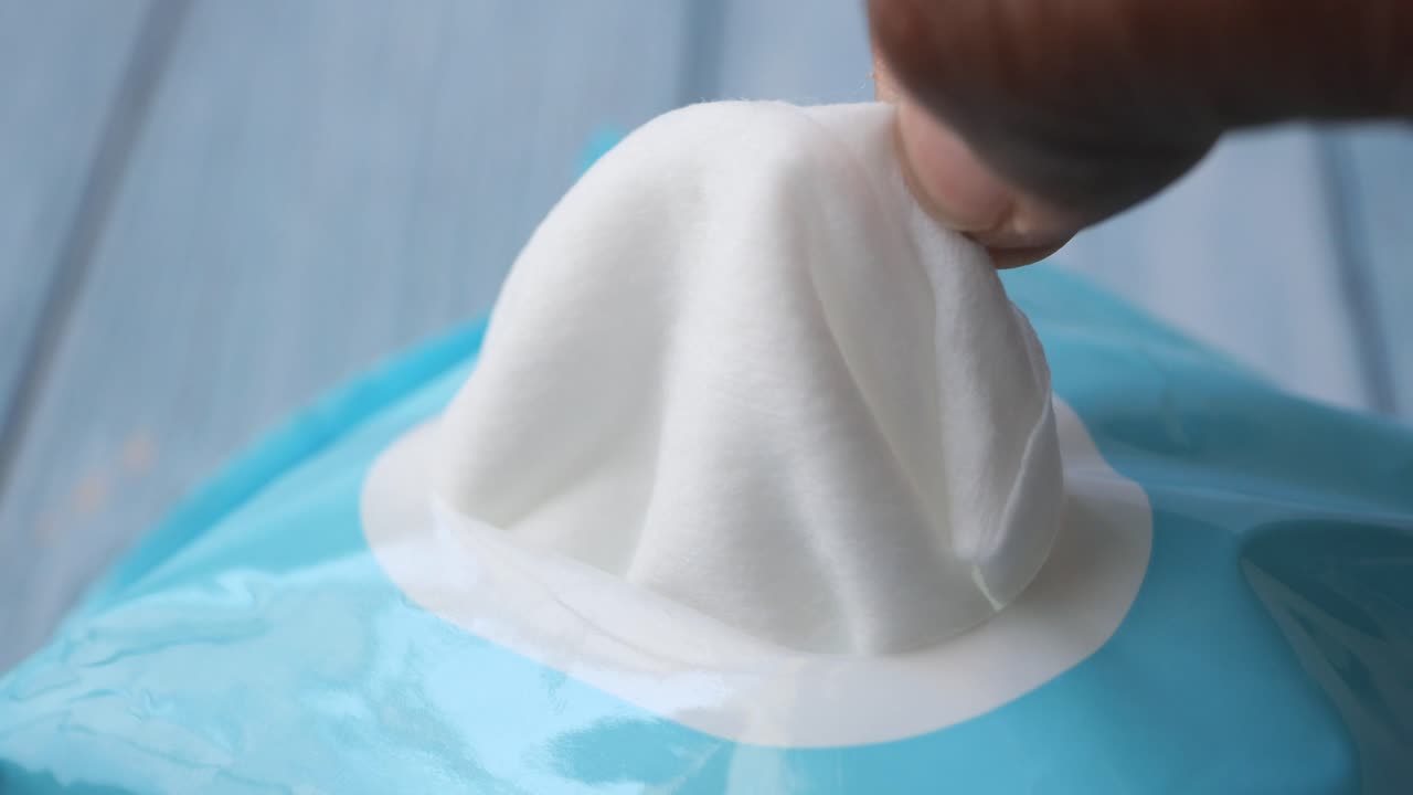 mano abriendo un paquete de toallitas húmedas