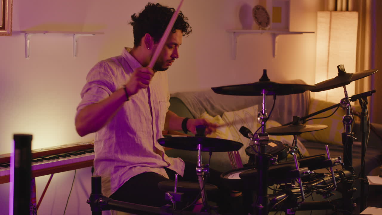Uomo che suona la batteria elettronica a casa