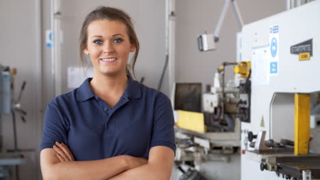 portrait of female engineer walking towards camera in workshop