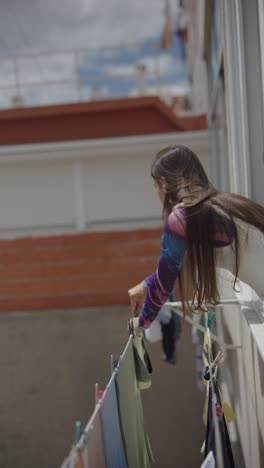 woman drying clothes on balcony