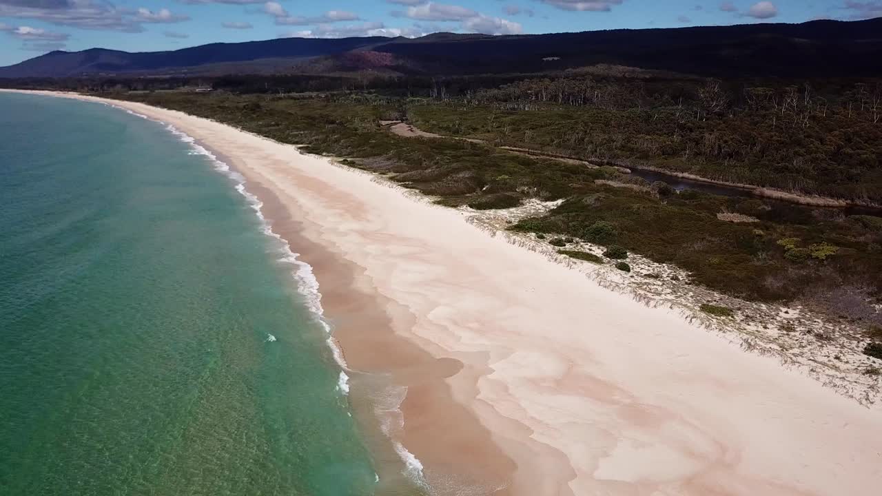 Panoramica con drone su una spiaggia di sabbia bianca e la costa dell'oceano blu in Tasmania, Australia