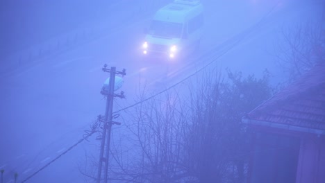 투어 버스 와 자동차 는 앞 에 유 ⁇ 리티 기둥 이 있는 흐릿 한 보라색 도로 를 따라 운전 한다
