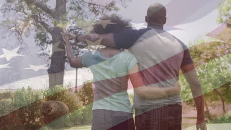 Animation-of-national-flag-of-america-over-rear-view-of-african-american-couple-walking-in-park
