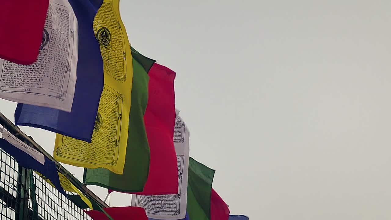 Buddhist prayer flags fluttering outdoors in India showing spirituality, peace, meditation culture, religious tradition, colorful flags moving in wind under open sky