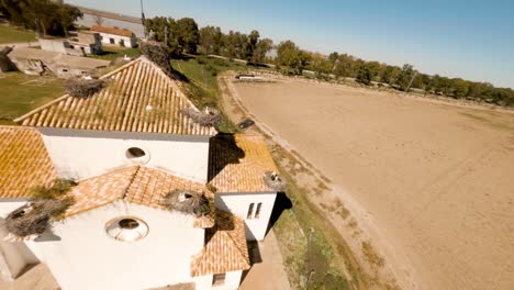 aerial circles in the hermitage of la señuela with storks in their nests on the roof