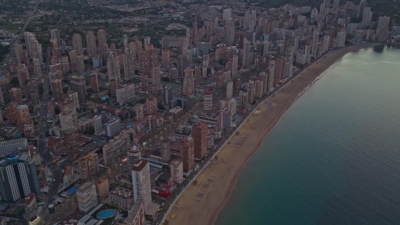 Veduta aerea che sorvola il paesaggio urbano di Benidorm all'alba.