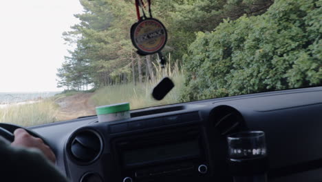 vista de la cabina de la camioneta conduciendo a través de un terreno accidentado por el océano