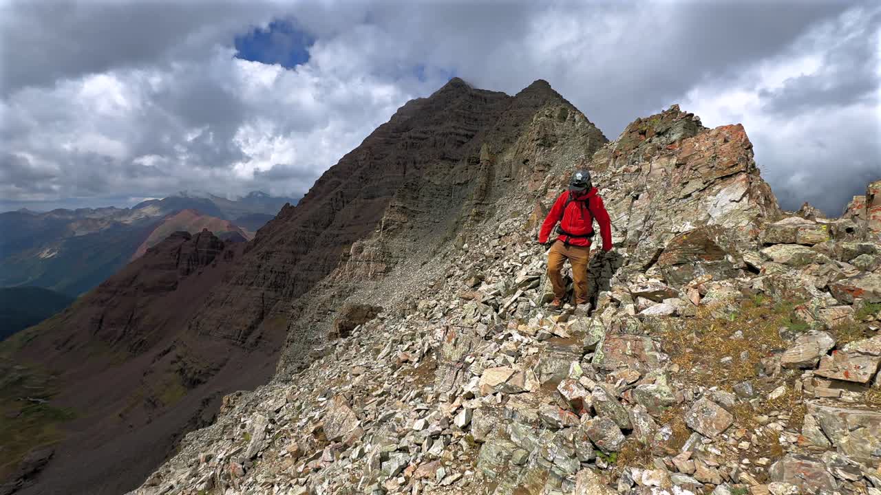 Backside Maroon Peak hiking trail down fourteener rugged mountain terrain Bells Wilderness Colorado summer sunny clouds dense fog movement Aspen Snowmass Elk Range Rocky Mountains static shot