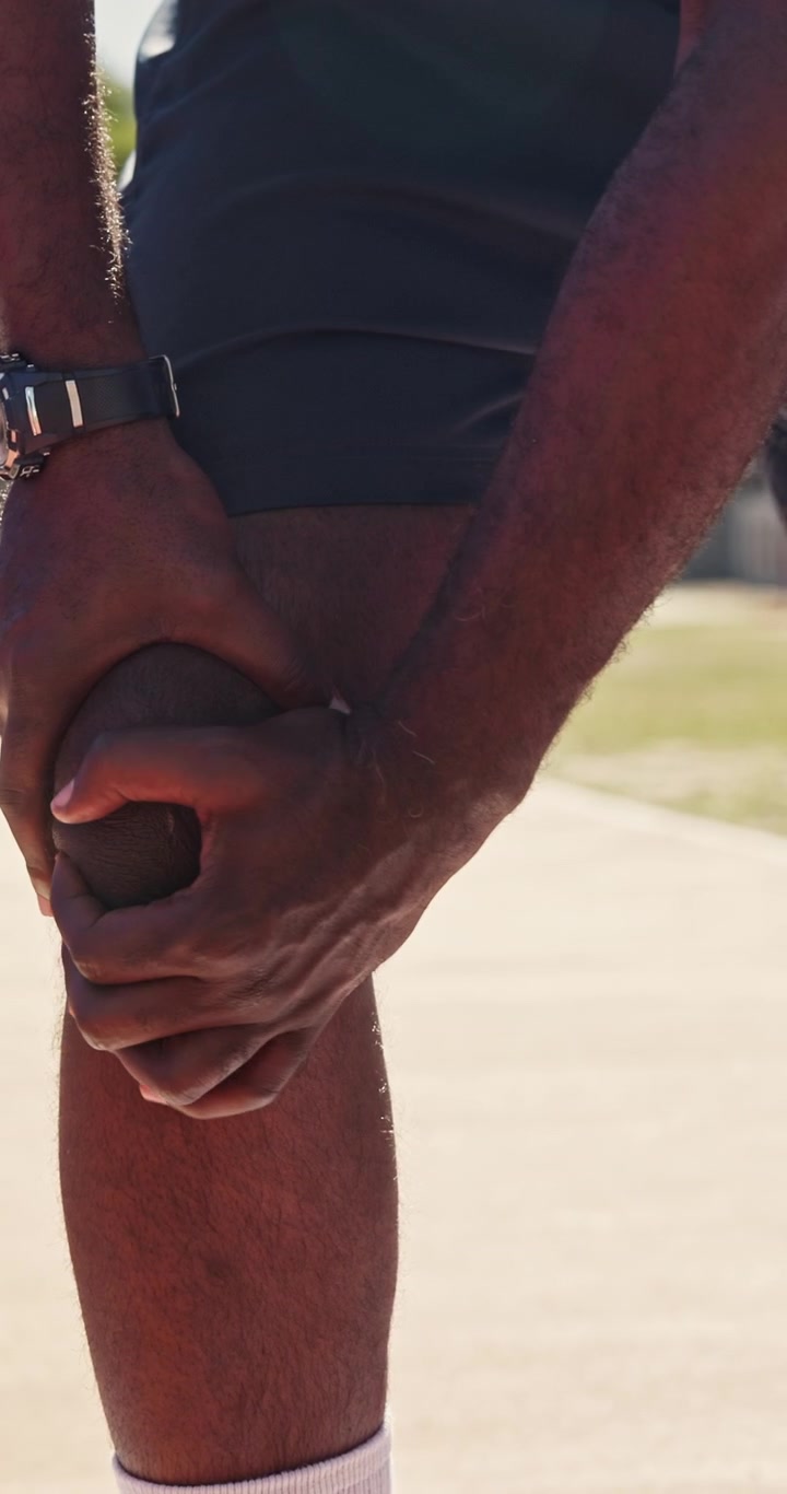 Atleta Massageando o Joelho Dolorido Após o Treino ao Ar Livre