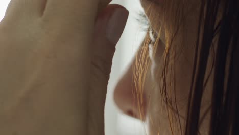 caucasian brunette woman brushing hair in bathroom in