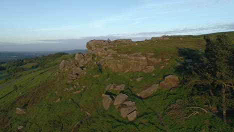 drone delantero disparó volando hacia la vaca y la formación rocosa de terneros en ilkley moor west yorkshire, reino unido
