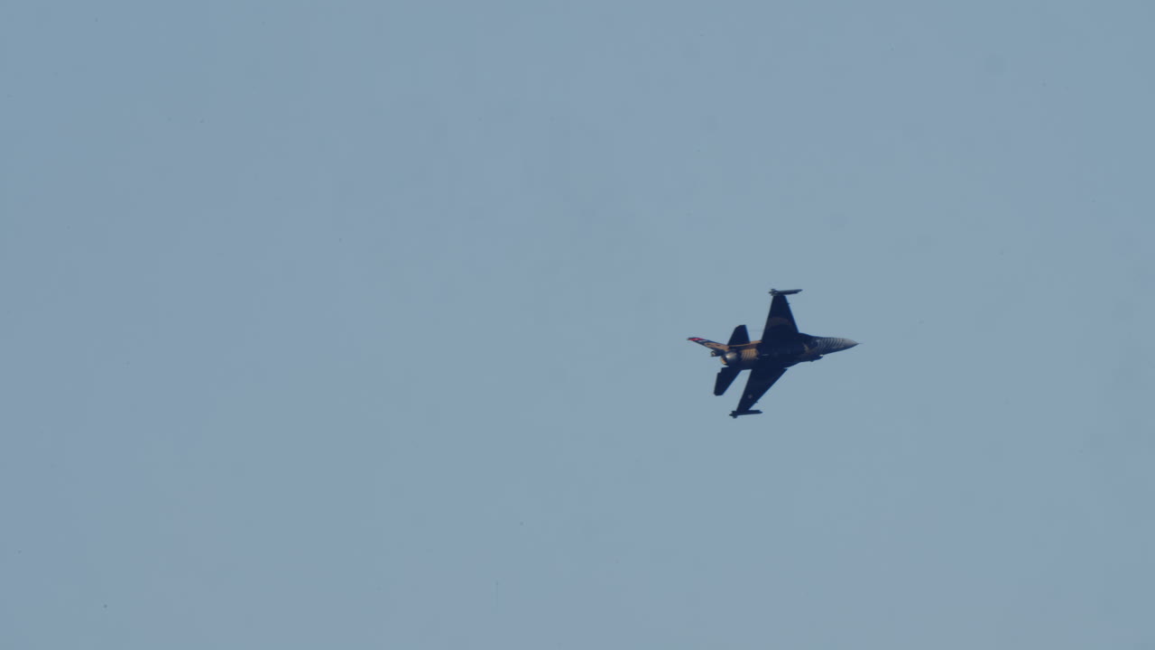 Pesawat Tempur F-16 Militer Terbang dengan Afterburner di Langit Cerah