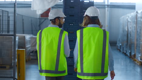 supervisores de la fábrica inspeccionando el almacén analizando el proceso de producción hablando