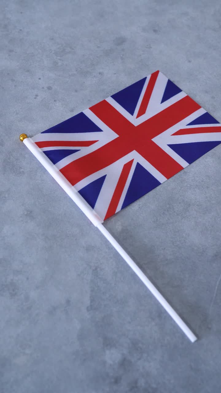 Bandiera del Regno Unito su sfondo grigio. Primo piano verticale. Bandiera nazionale britannica.