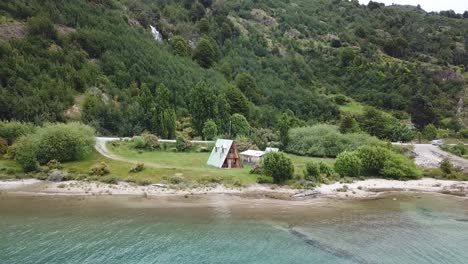 Summer-in-Chilean-Patagonia,-Pull-Back-Aerial-View-of-Houses-and-Coast-of-General-Carretera-Lake,-Chile