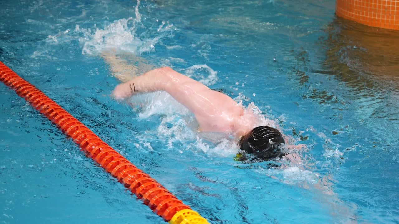 수영장 에서 자유 스타일 로 수영 하는 사람